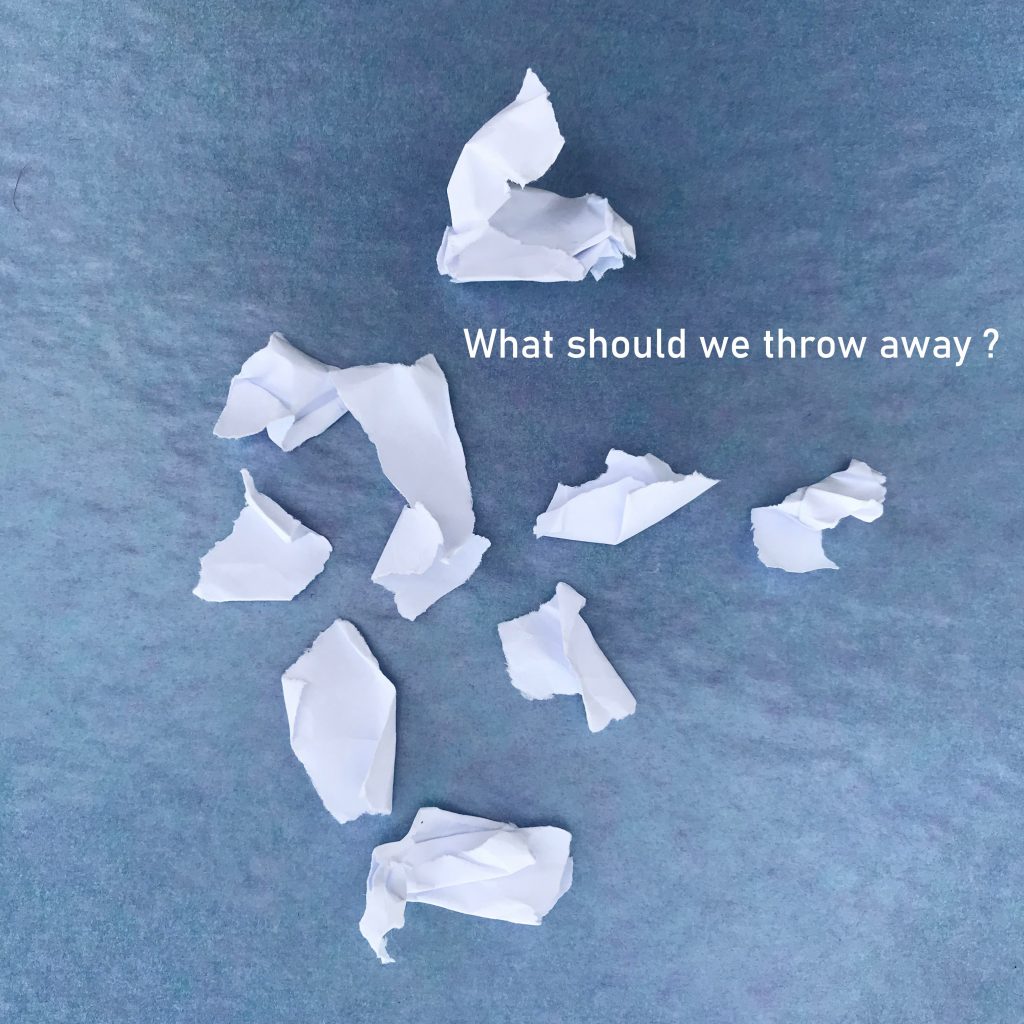 “what should we throw away” written in white on an image of white pieces of torn paper scattered on a sky blue square.