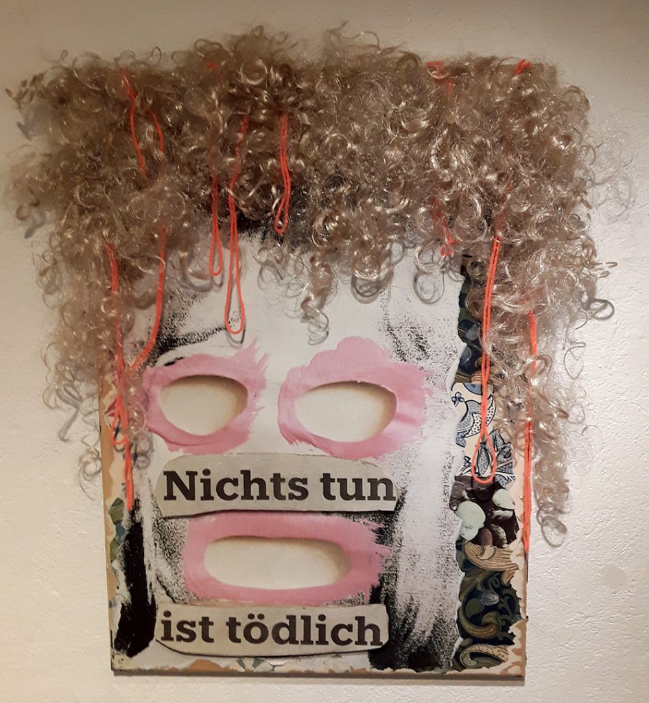 Foto einer Maske mit den Worten "Nichtstun ist tödlich" über das Gesicht geschrieben